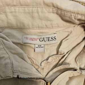 Cream colored guess lightweight jacket with collar and fashionable front pockets